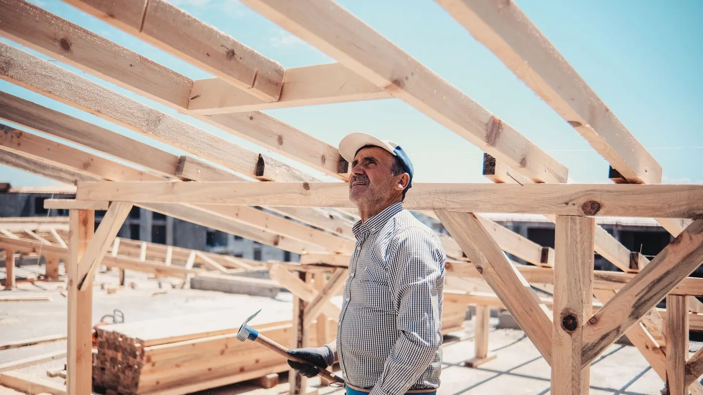 Builder inspecting a timber roof frame on site