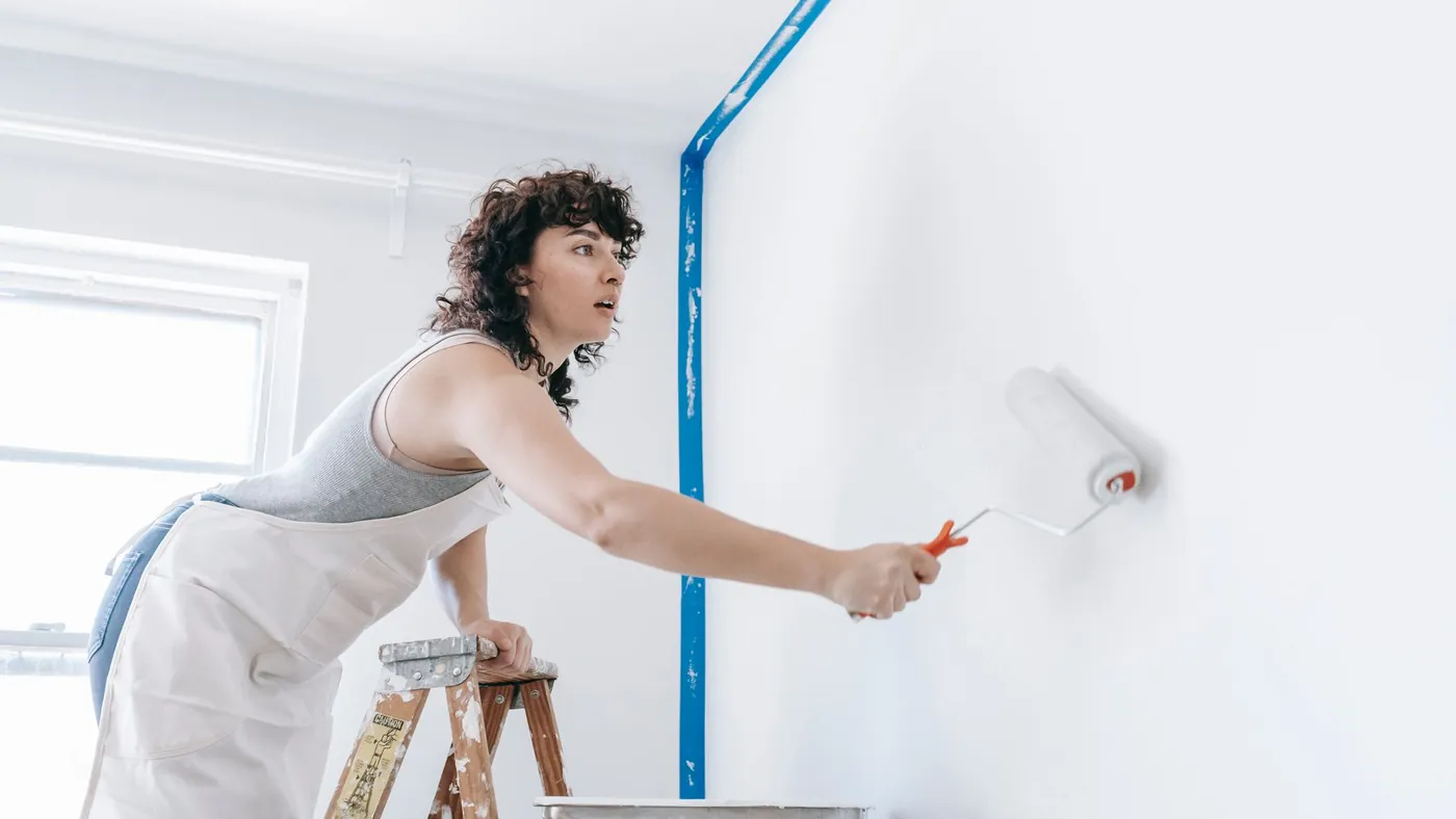 Decorator painting a wall with a roller