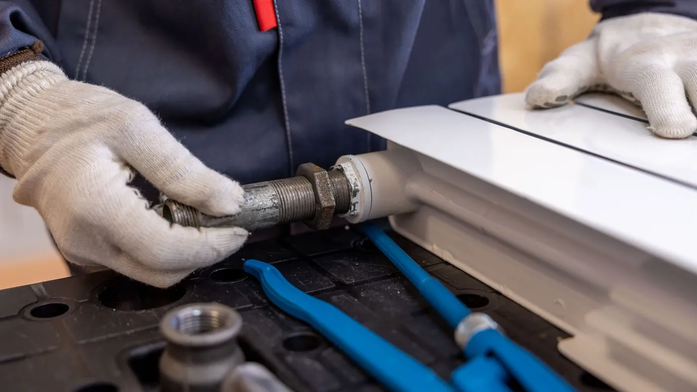 Plumber installing a radiator pipe